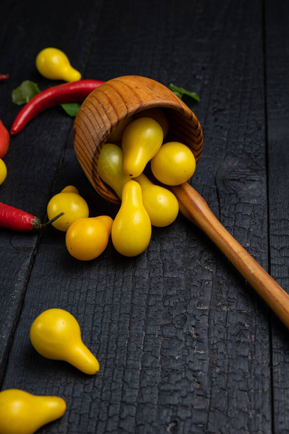 Wooden spoon on a dark background with vegetables - 写真・画像