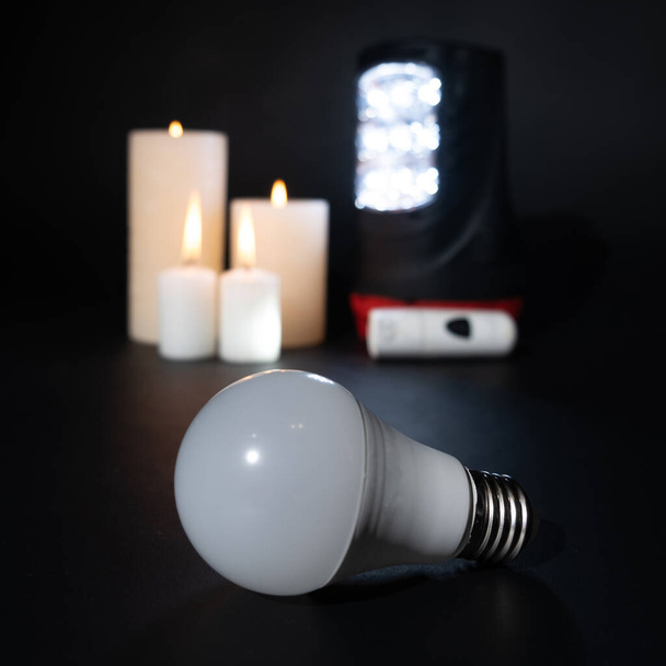 Queda de energia, ataque a usinas de energia na Ucrânia a lâmpada não brilha, lanternas e velas como fontes de luz e calor. - Foto, Imagem