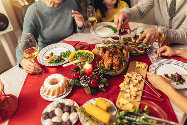 Sluiten van voedsel tijdens familiediner aan eettafel. - Foto, afbeelding
