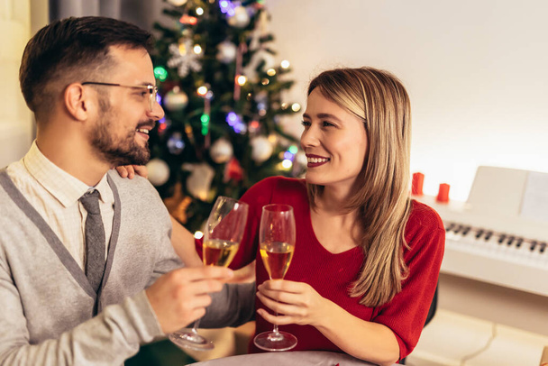 Casal beber vinho e rir enquanto se senta em torno de uma mesa de jantar durante um jantar  - Foto, Imagem
