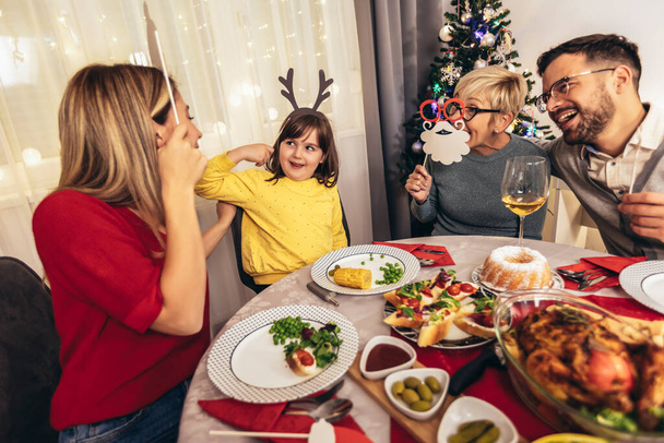 Šťastná vícegenerační rodina si užívá oběd doma. Rodina na vánoční večeři doma - Fotografie, Obrázek
