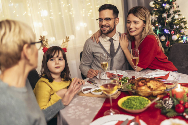 Счастливая семья из нескольких поколений наслаждается обедом вместе дома. Семья на рождественский ужин дома - Фото, изображение