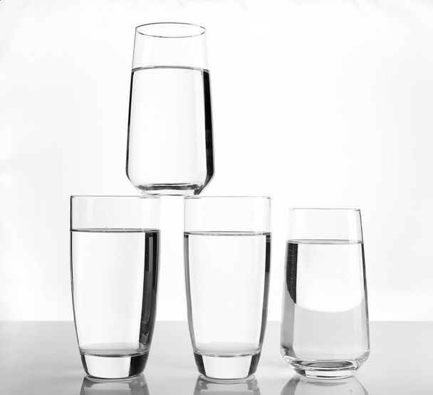 Glasses of water on light background - 写真・画像