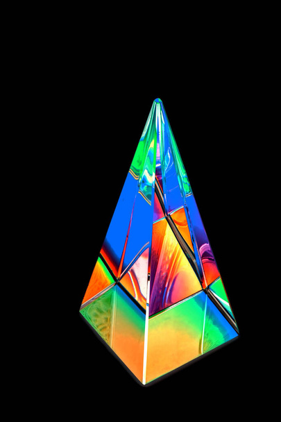 Glass pyramid prism with colorful light reflection on black background with copy space - Foto, afbeelding