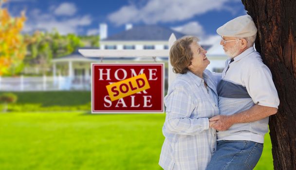 Продается Знак Недвижимости с пожилой парой перед домом
 - Фото, изображение