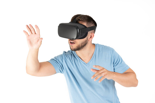 Jongeman speelt met een VR bril op een perfecte witte achtergrond. - Foto, afbeelding