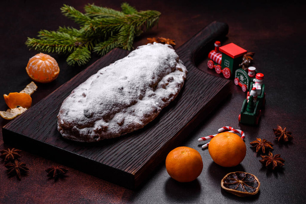 Kerst taart stollen met marsepein, bessen en noten op een donkere betonnen achtergrond. Voorbereiding van de feestabel - Foto, afbeelding