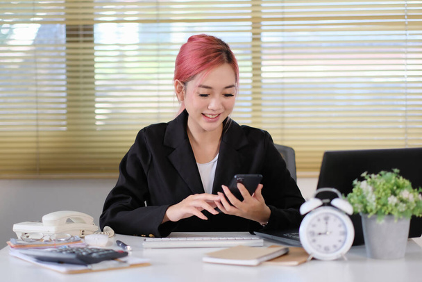 Nuori aasialainen liike nainen käyttää älypuhelinta
   - Valokuva, kuva