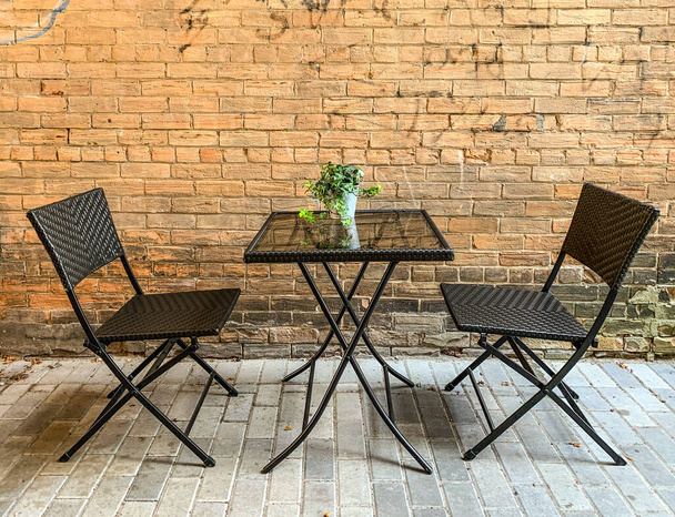 Asztal és székek mellett külső téglafal a teraszon - Fotó, kép