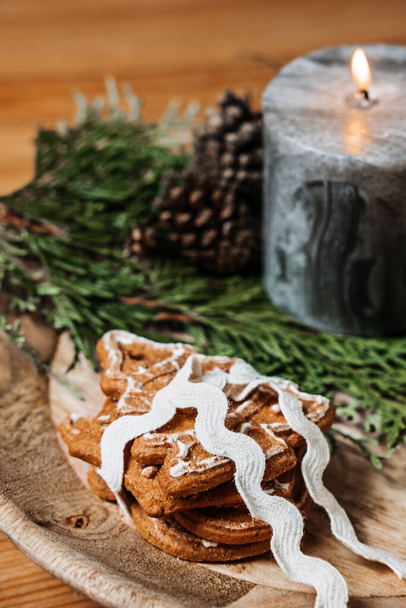 Geen cadeau Kerstideeën voor familie, vrienden voor een anti-consument kerst. Xmas zelfgemaakte peperkoek koekjes met lint, dennenboom en handgemaakt met liefde label op houten tafel. - Foto, afbeelding
