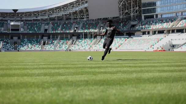 Αφροαμερικάνος που παίζει ποδόσφαιρο στο γήπεδο. - Φωτογραφία, εικόνα