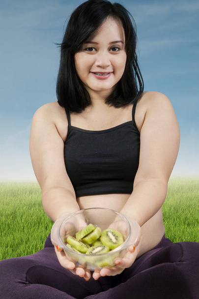 Kobieta w ciąży daje Owoce kiwi - Zdjęcie, obraz
