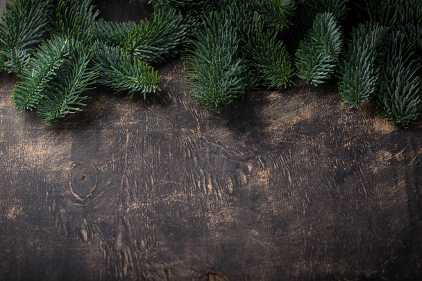 Χριστούγεννα και Πρωτοχρονιά φόντο με έλατο treeon μαύρη ξύλινη επιφάνεια - Φωτογραφία, εικόνα