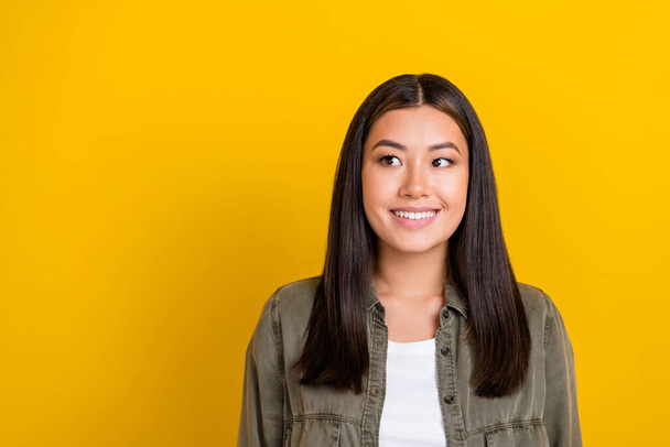 Photo of gorgeous excited cheerful woman with straight hairdo dressed gray shirt look empty space isolated on yellow color background. - Foto, Bild