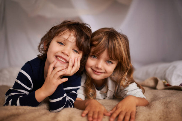 My sister has the best brother ever. Portrait of two adorable siblings lying underneath a fort - Fotografie, Obrázek