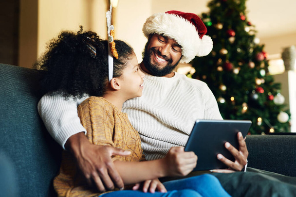 Karácsonyi, családi és digitális tabletta élő streaming film, szórakoztató játék vagy a közösségi média ház nappali kanapé. Boldog mosolyt anya, apa és a lány a technológia otthon ünnepi karácsonyi ünnep. - Fotó, kép
