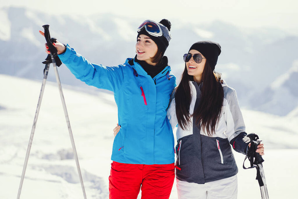 two young and active brunette skiing in the snowy mountains - Zdjęcie, obraz