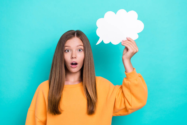 Photo of funny excited young teen girl wear orange sweatshirt hold paper cloud unexpected phrase eureka isolated on cyan color background. - Zdjęcie, obraz