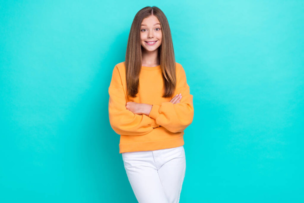 Photo of young funny positive girl folded arms wear orange sweatshirt confident person satisfied her new outfit isolated on cyan color background. - Valokuva, kuva