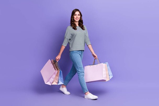 Full length photo of adorable client customer fashionista trendy outfit carry clothes move empty space isolated on purple color background. - Fotó, kép