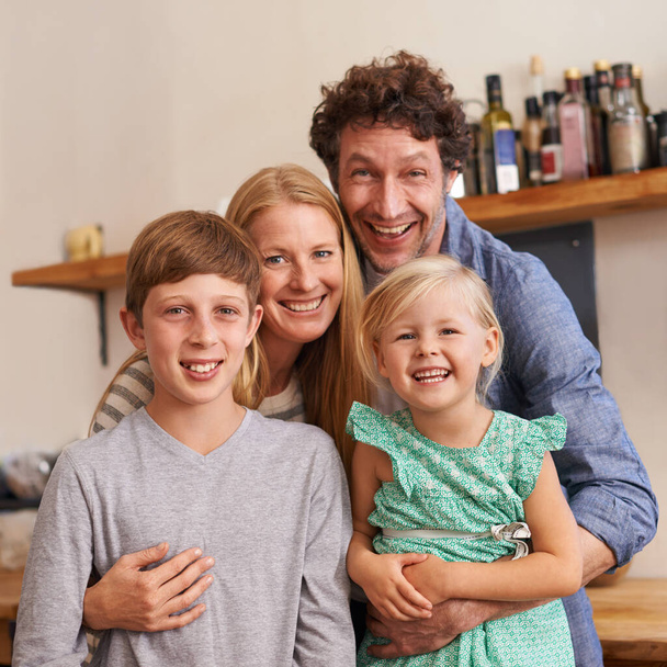 Een gelukkig en liefdevol gezin. Een bijgesneden portret van een gelukkig gezin dat thuis in hun keuken staat - Foto, afbeelding