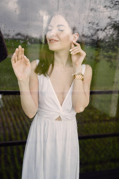 Girl by the window. Lady in a white dress. - Foto, Bild