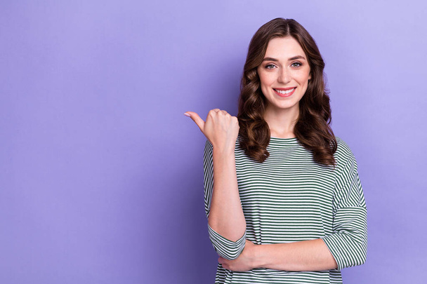 Photo of cute girlish woman wear striped pullover thumb directing empty space advertisement deal promo isolated on purple color background. - Fotoğraf, Görsel