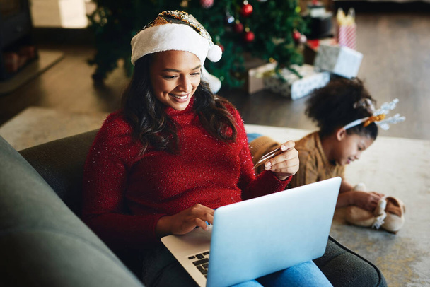 クリスマスオンラインショッピング、電子商取引やインターネットやオンラインでの支払いのためのクレジットカードやラップトップを持つ女性。休日小売販売,家族や床で遊んで母親と子供とのeコマース - 写真・画像