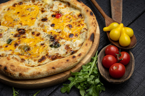 tasty pizza with cheese and vegetables on a wooden dark table - Foto, Imagem