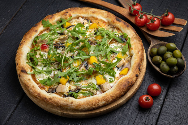 tasty pizza with cheese and vegetables on a wooden dark table - Photo, image