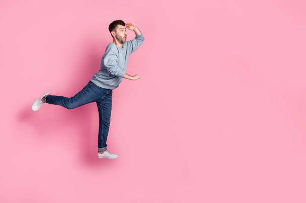 Full body photo of nice young guy carry cart look empty space hand forehead dressed trendy blue clothes isolated on pink color background. - Fotó, kép