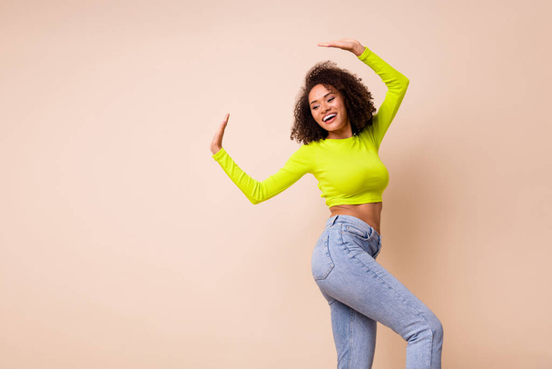 Portrait of young dancing happy celebrating girl winner dance good mood looking empty space isolated on beige color background. - Φωτογραφία, εικόνα