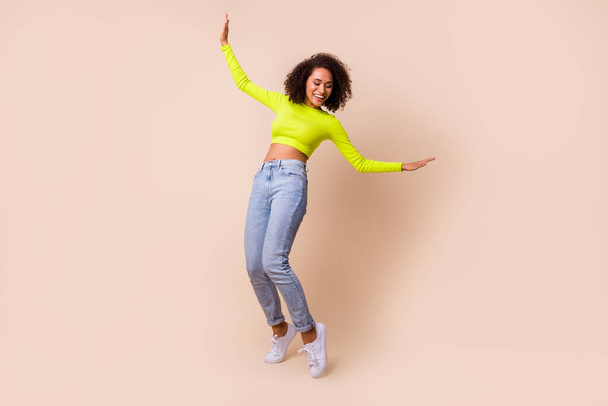 Full length photo of young happy smiling woman drunk dancing showing elastic isolated on beige color background. - Valokuva, kuva