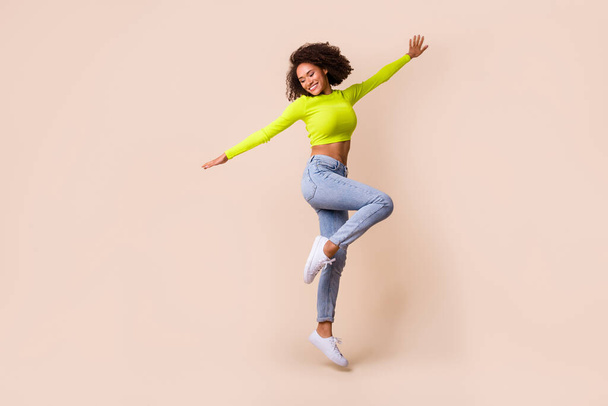 Full length photo of young attractive girl happy go travel fly wings dancing isolated on beige color background. - Zdjęcie, obraz