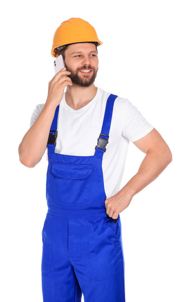 Professional repairman in uniform talking on smartphone against white background - Фото, зображення
