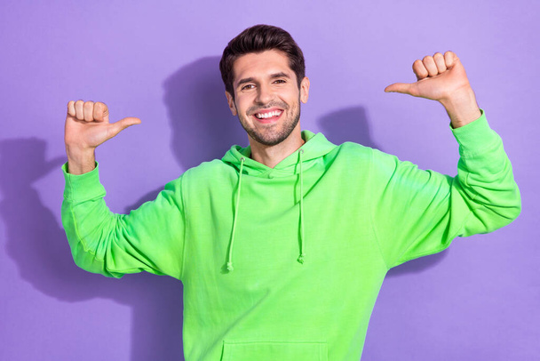 Portrait of good mood nice self confident guy with brunet hairdo green hoodie directing at himself isolated on violet color background. - Photo, Image