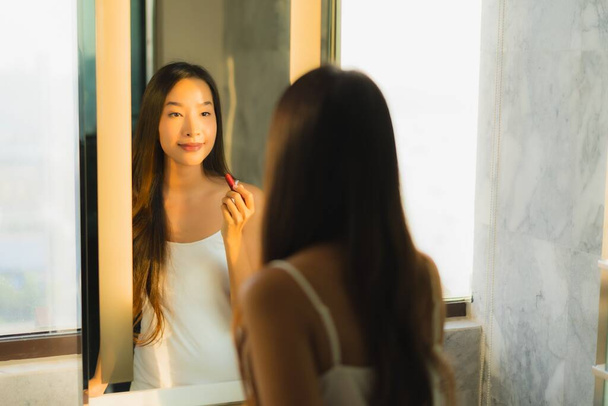 Portrait beautiful young asian woman make up with cosmetic powder and lipstick on her face facial in bathroom interior - Foto, Bild