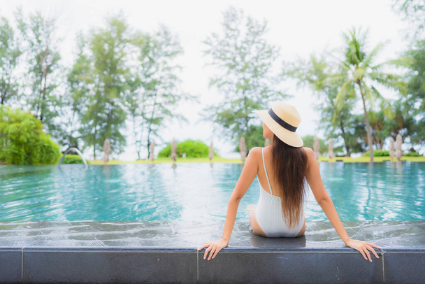 Retrato bonito jovem asiático mulher relaxar sorriso lazer ao redor piscina ao ar livre no hotel resort quase mar praia - Foto, Imagem