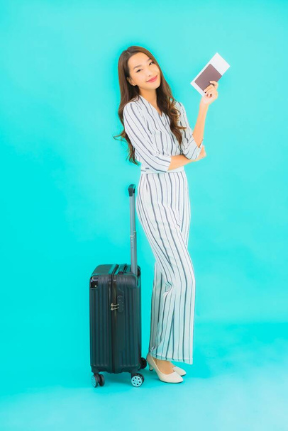 Портрет красивая молодая азиатка с багажным паспортом и посадочным талоном готовы к путешествию на синем фоне - Фото, изображение