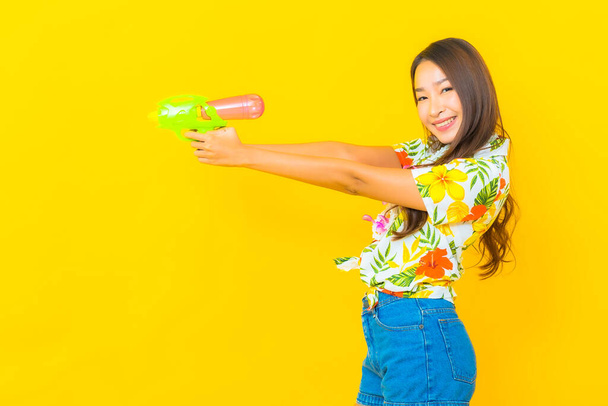 Portrait beautiful young asian woman wear colorful shirt with water gun for sonkran festival - Foto, Imagem