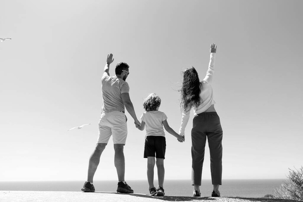 life insurance. adoption and achievement. back view. father mother and child in summer. friendly family. family travel vacation. happy parents with kid boy. mom dad and son love relax together. - 写真・画像