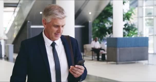 Phone, portrait and thumbs up with senior manager walking through an office for business deal or negotiation. Thank you, communication and success with a man CEO employee on a smartphone on his walk. - Footage, Video