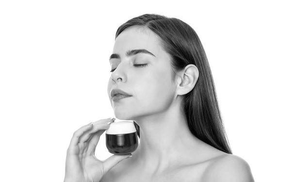 jonge vrouw houden crème pot voor gezicht huid geïsoleerd op witte achtergrond, cosmetische. - Foto, afbeelding