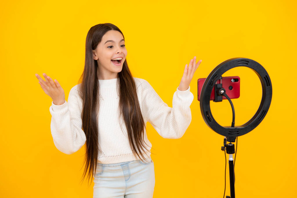 Teenager child recording video tutorial for social media with smart phone. Influencer teenager creating new content for blog while streaming online - Foto, immagini
