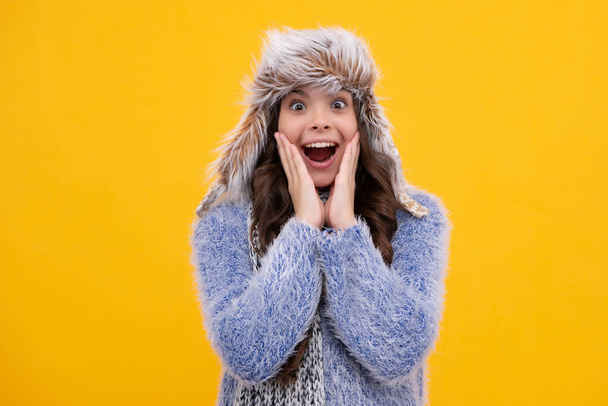 Winter hat. Cold season concept. Winter fashion accessory for children. Teen girl wearing warm knitted hat. Surprised teenager girl - Φωτογραφία, εικόνα
