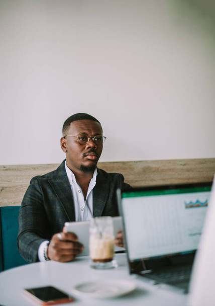 Hombre de negocios sosteniendo su tableta mientras mira a su colega en el café - Foto, Imagen