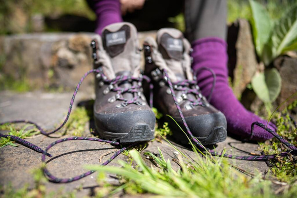 Amarrar cadarços em botas de caminhada por uma menina em uma caminhada na primavera - Foto, Imagem