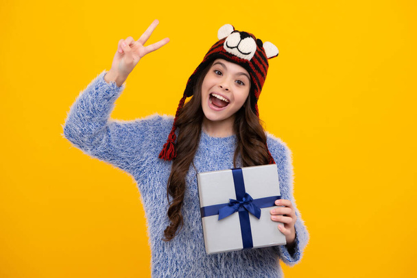 Amazed teenager. Teenager child in winter wear holding gift boxes celebrating happy New Year or Christmas. Winter kids holiday. Excited teen girl - Foto, Imagem