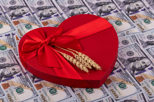 Уши пшеницы, подарочная коробка в виде сердца и векселя в 100 американских долларов - Фото, изображение