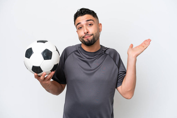 Arabi nuori jalkapalloilija mies eristetty valkoisella taustalla ottaa epäilyksiä nostaessaan kädet - Valokuva, kuva